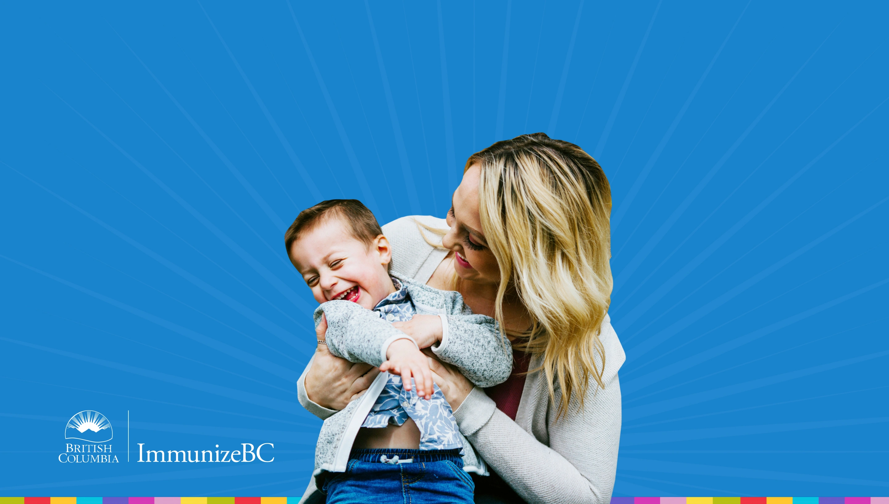 Woman smiling and holding a laughing child. Province of BC logo and Immunize BC logo. 