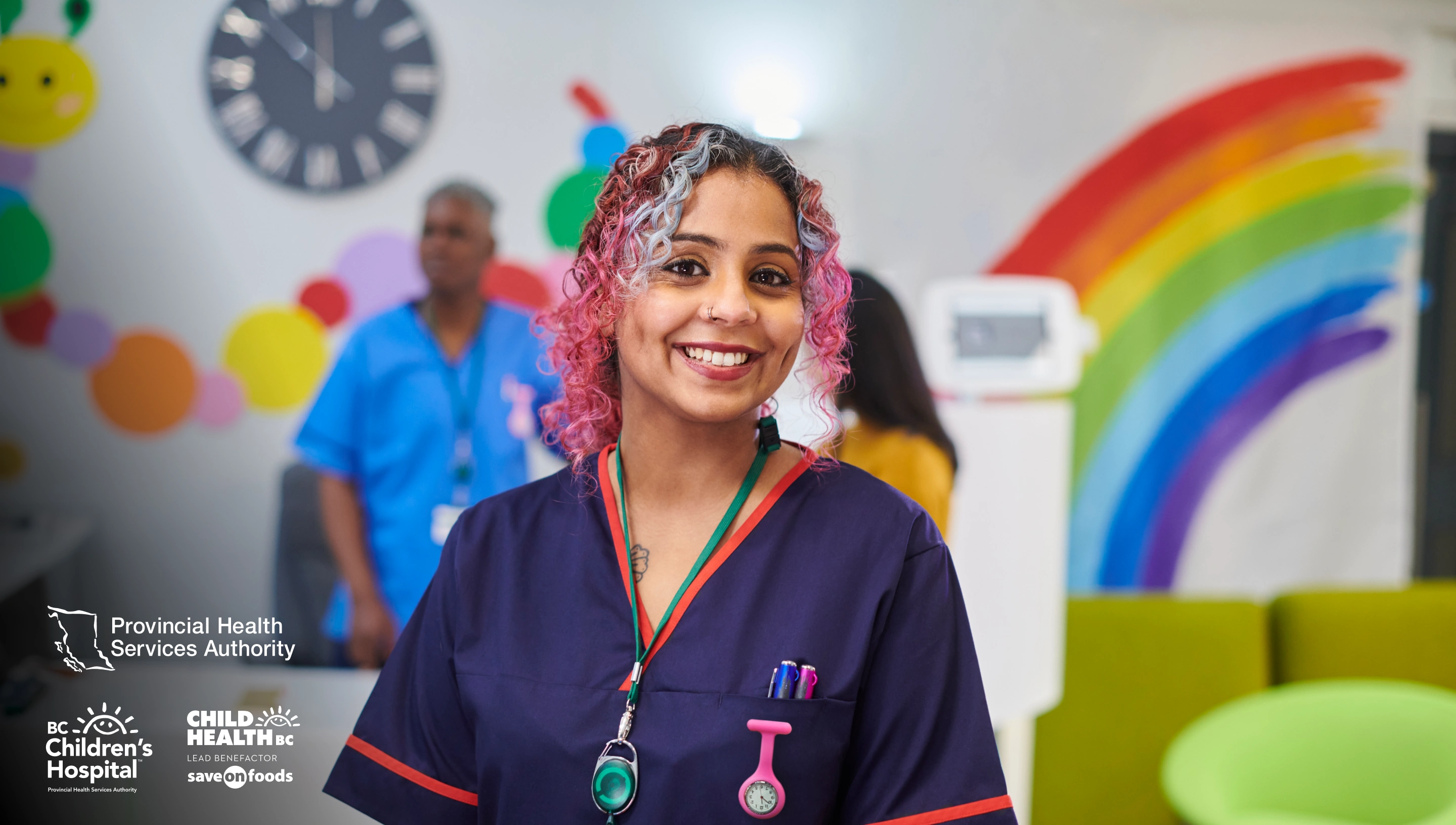 Photo of a health professional in scrubs, smiling at the camera