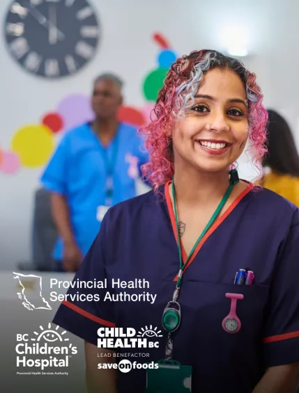 Photo of a health professional in scrubs, smiling at the camera